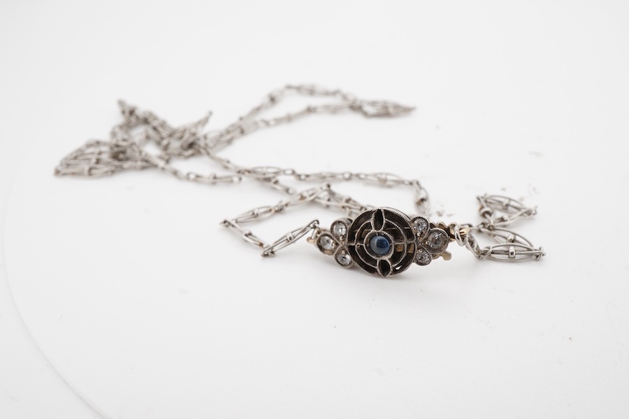 A platinum chain necklace, early 20th century, of fancy linking, to a cabochon sapphire and paste clasp, length 49cm, indistinct assay mark